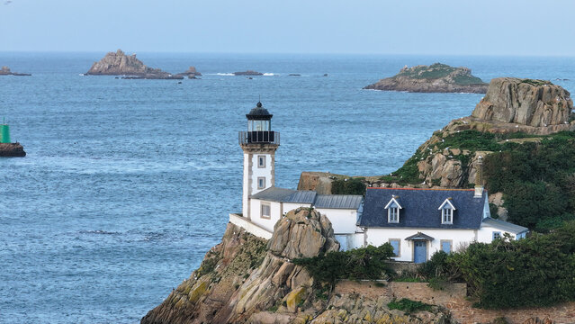 Aerial view of Louet island featuring the lighthouse and keeper's cottage on rocky cliffs overlooking the sea Carantec, Brittany, France.