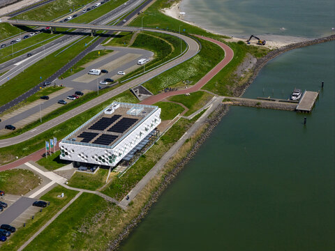 Kornwerderzand, Netherlands - 14 May 2026: Aerial view of the Afsluitdijk Wadden Center with its modern architecture, solar panels, and surrounding green landscape by the water.