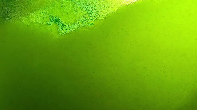 green ice cream tank. Ice cold sorbet machine mixing fruit juice. Freezing slush spinning around, summer treat.