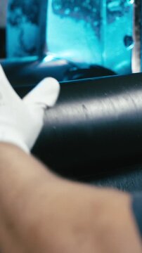 Person rolling together rubber sheet close-up