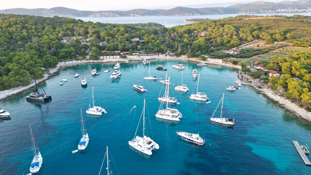 Hvar, Croatia - 21 August 2023: Aerial view of Vinogradisce bay with numerous yachts and sailboats anchored in turquoise waters surrounded by lush green hills.