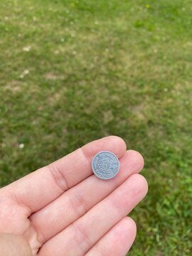 Mano che regge una moneta