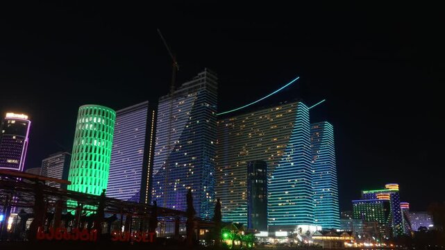 Panning timelapse of evening illumination of modern skyscrapers in Batumi at night. Glowing Batumi panorama with Orbi City and House of Justice. Capital of Adjara