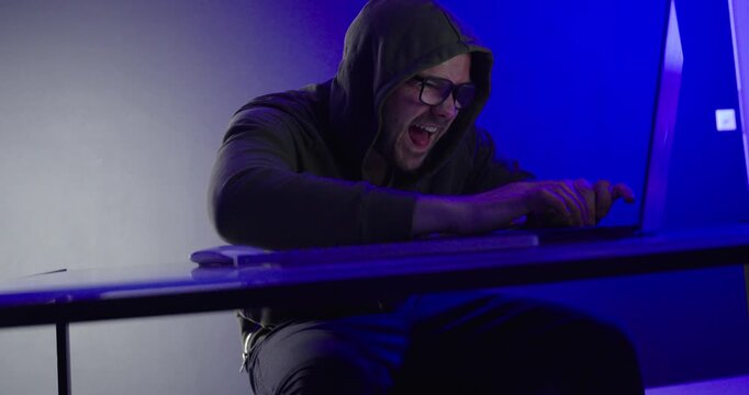Malicious Hacker Celebrating Cyber Attack Success in Blue Neon Light