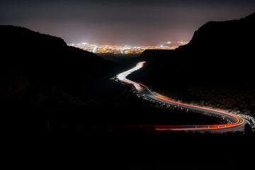 Glowing car light trails beneath star-filled sky © CL Productions