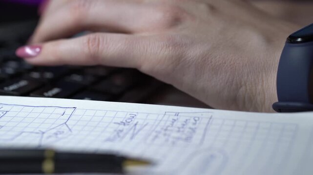Pen resting on sketched architecture diagram in notebook beside blurred hands and keyboard, ink lines mapping system components and annotated connections, crisp lighting and focused planning