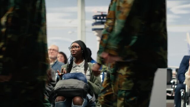 Soldier in camouflage walks past departures board and seated passengers in airport terminal, creating a busy military travel scene during delayed flights.