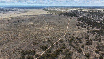 Fototapeta premium Madura, Western Australia – 4K aerial drone view of remote outback highway, arid landscape, bushland and vast inland plains