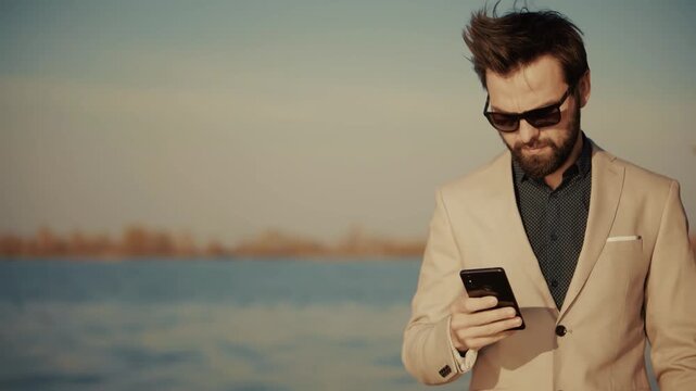 Businessman Using Smartphone Standing Near River. Corporate Employee Reading Message On Mobile Phone Screen