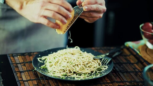 Hands Grating Hard Cheese With Grater Onto Pasta. Preparing Hot Spaghetti Dish. Italian Cuisine
