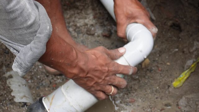 Plumber assembling pvc sewage pipes with skilled precision