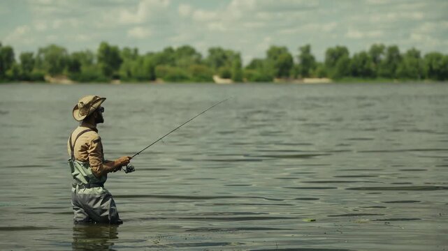 Fisherman Holding Spinning Rod Standing In River Water. Angler Fishing On Lake. Hobby And Activity Leisure 