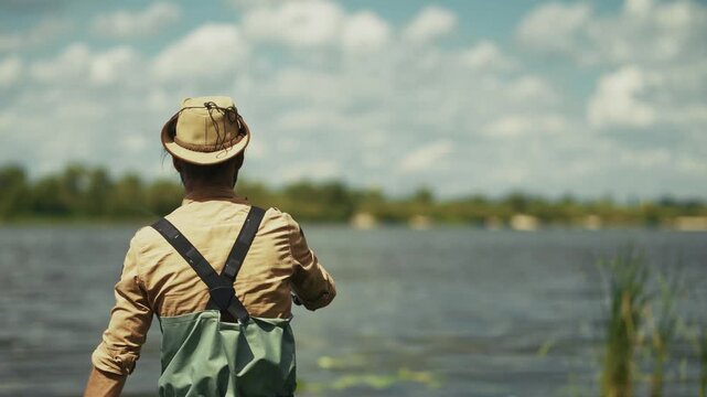Fisherman Casting Fishing Rod In River. Angler Throwing Bait Catching Fish Near Shore. Outdoor  Recreation And Hobby
