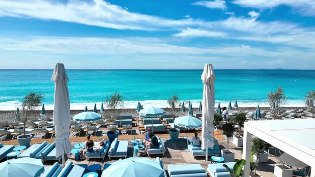 tropical beach with umbrellas and chairs in Nice