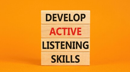 Naklejka premium Wooden blocks spelling 'develop active listening skills' with listening communication education learning business