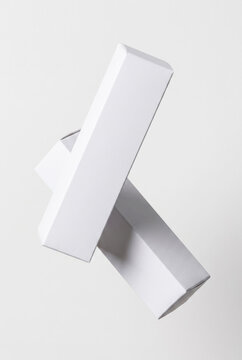 Two White Long Rectangular Packaging Boxes Floating in Mid-Air Abstract Composition