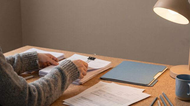 Invoice sorting on a cork desk in a home office