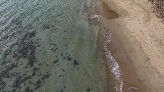 Oblique aerial 4K drone view of tropical beach shoreline and shallow sea water in Puerto Princesa, Philippines