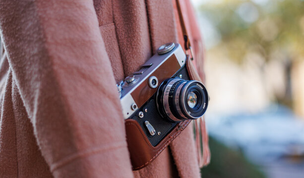 girl with a camera while walking. fashion and style. hipster girl takes pictures with a film camera. lifestyle concept.