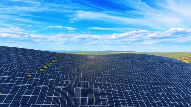 Close up aerial view of massive solar panel array texture. High-angle detailed drone shot of endless photovoltaic panels forming a geometric pattern under blue sky.