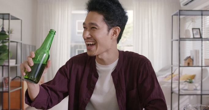 Happy hour good warm summer time diner indoor home. Group of asia people young adult friend man and woman sit at dining table joy fun talk or eat food and drink beer alcohol bottle glass inside house.