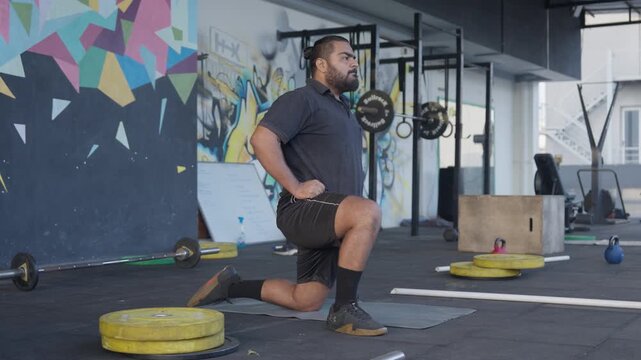 A focused Indian male athlete in black athletic wear performs controlled hip hinge mobility exercise with hands on hips at an outdoor urban gym. Clean side profile shot captures forward and backward t
