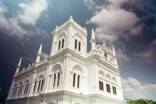 View of the historic white Meeran Jumma Mosque with its colonial architecture and minarets under a dramatic cloudy sky in Galle, Southern Province, Sri Lanka.