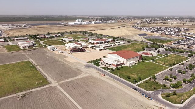Drone perspective of the West Hills College Lemoore campus in California, showcasing the academic buildings, surrounding landscape, and adjacent residential areas on a bright sunny day
