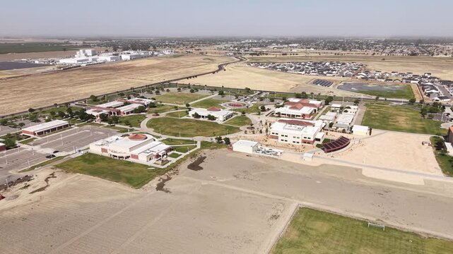 Extensive aerial view showcasing the sprawling campus of Lemoore College, with its modern buildings, green spaces, and surrounding agricultural and residential areas