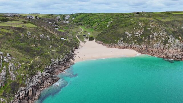 Beautiful aerial approach video of Porthcurno Beach showcasing turquoise waters, golden sand and dramatic cliffs along Cornwall&rsquo;s breathtaking coastline.