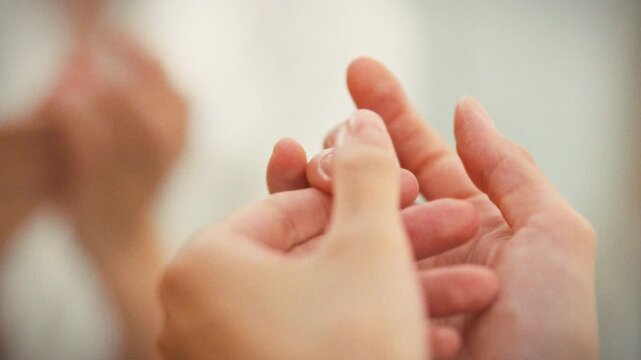 In a personal grooming setting, a girl gently massages her cuticles with a softening agent as part of her daily nail care routine, promoting hand beauty and health through nourishment and hydration
