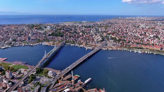 4K aerial view of Istanbul's Golden Horn with Atat&uuml;rk Bridge, Hali&ccedil; Metro Bridge and S&uuml;leymaniye Mosque on the historic peninsula extending to the Sea of Marmara horizon.