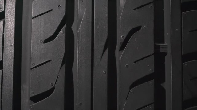 Car Tire Tread Close Up. The surface of a car tire slowly floats in front of the camera close-up