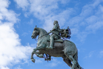 Fototapeta premium Bronze royal monument to Felipe IV against blue sky at Plaza de Oriente, Madrid, Spain