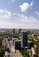 Obraz premium Modern high rise building in Kyiv with wavy glass facade, aerial cityscape photography under blue sky Ukraine