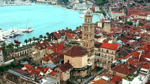 Cinematic aerial drone footage of Split featuring the Adriatic coastline, historic old town, marina, and Mediterranean atmosphere. Ancient architecture mixed with modern coastal life