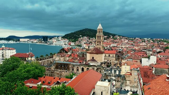Cinematic aerial drone footage of Split featuring the Adriatic coastline, historic old town, marina, and Mediterranean atmosphere. Ancient architecture mixed with modern coastal life