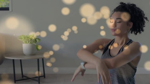 Woman taking breath cue and performing home stretches for wellness, bokeh highlighting wrist watch