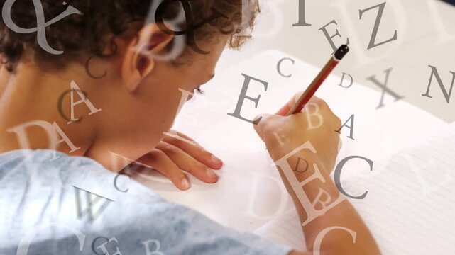 Boy leaning at table, pencil touching paper, learning letters with letters floating over hands