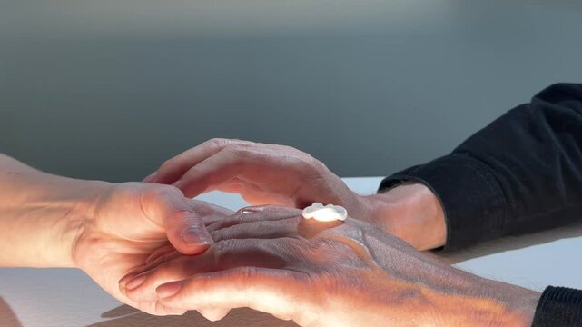 Hands apply cream to another hand in close up. Skincare treatment continues with gentle contact and product spread. Wellness, beauty, and personal care concept..