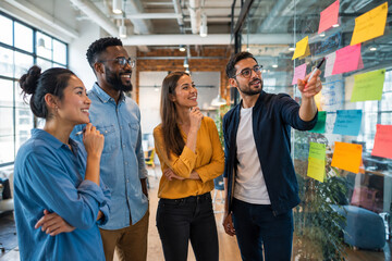 Obraz premium Diverse Business Team Brainstorming with Sticky Notes in Modern Office