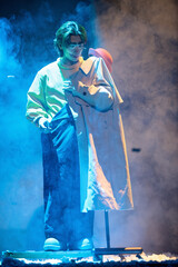 Obraz premium Clown-dressed comedians performing prop misdirection on stage