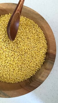 Vertical video. A spoon mixes the grits. Celiac disease. Millet as a natural alternative suitable for people with gluten intolerance. Health care, diet control and adherence to a specialized diet