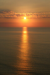 Obraz premium Golden Sunset over Calm Sea with Sun Path Reflection