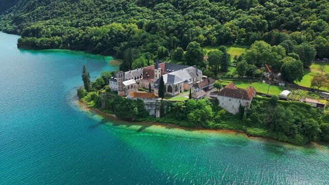 aerial shot around Hautecombe royal Abbey on the shores of the Lac du Bourget in Saint Pierre de Curtille near aix les bains on a sunny day in Savoie departement, Auvergne Rhone Alpes region, France