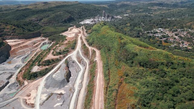 Slow drone flyover above quarry near Bras&iacute;lia, Distrito Federal, Brazil, revealing erosion scars, deforestation, haul roads, exposed geology, and transformed Cerrado terrain.