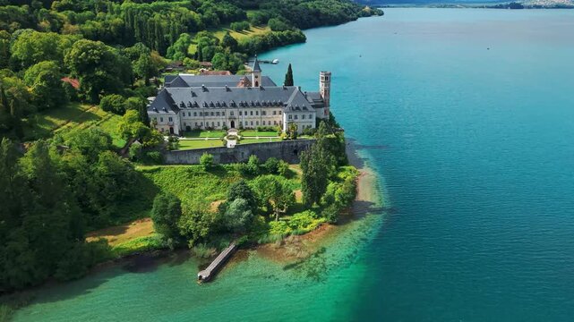 Aerial shot revealing Hautecombe Royal Abbey on the shores of the Lac du Bourget near Aix les Bains during spring in Savoie departement, Auvergne Rhone Alpes region, France