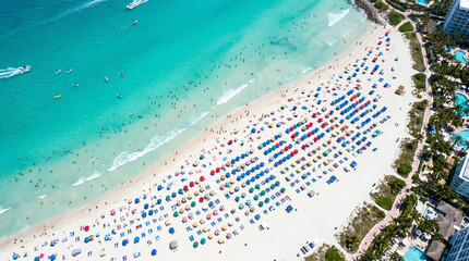 Fototapeta premium Summer Beach Aerial Diagonal View with Turquoise Water, Colorful Umbrellas, Water Sports and Hotel Buildings