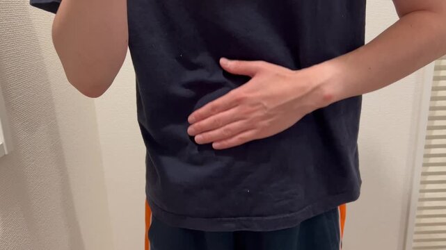 腹痛でお腹をさする男性