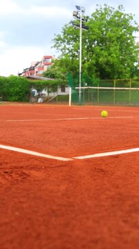 Bright Green Tennis Ball Bouncing on Outdoor Clay Court, Close Up Sports Action on Orange Sand Surface During Training Match, Dynamic Tennis Scene With Motion and Athletic Equipment in Sunny Weather